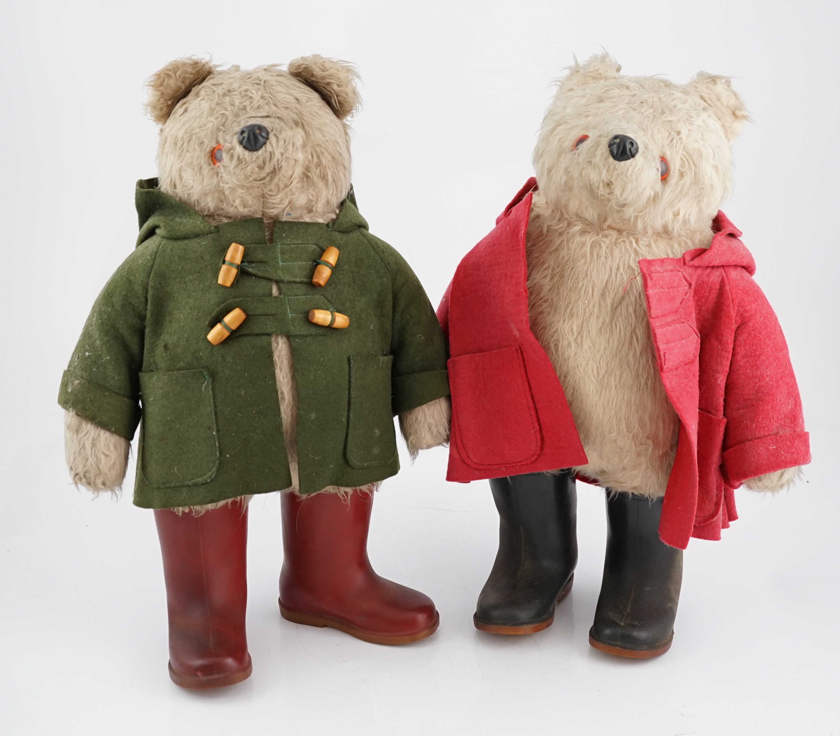 An early Paddington bear, green jacket, missing hat, and a similar Paddington with Dunlop boots, red jacket, missing hat (2)